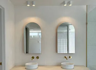 Downlights installed above twin arched mirrors in a finished bathroom