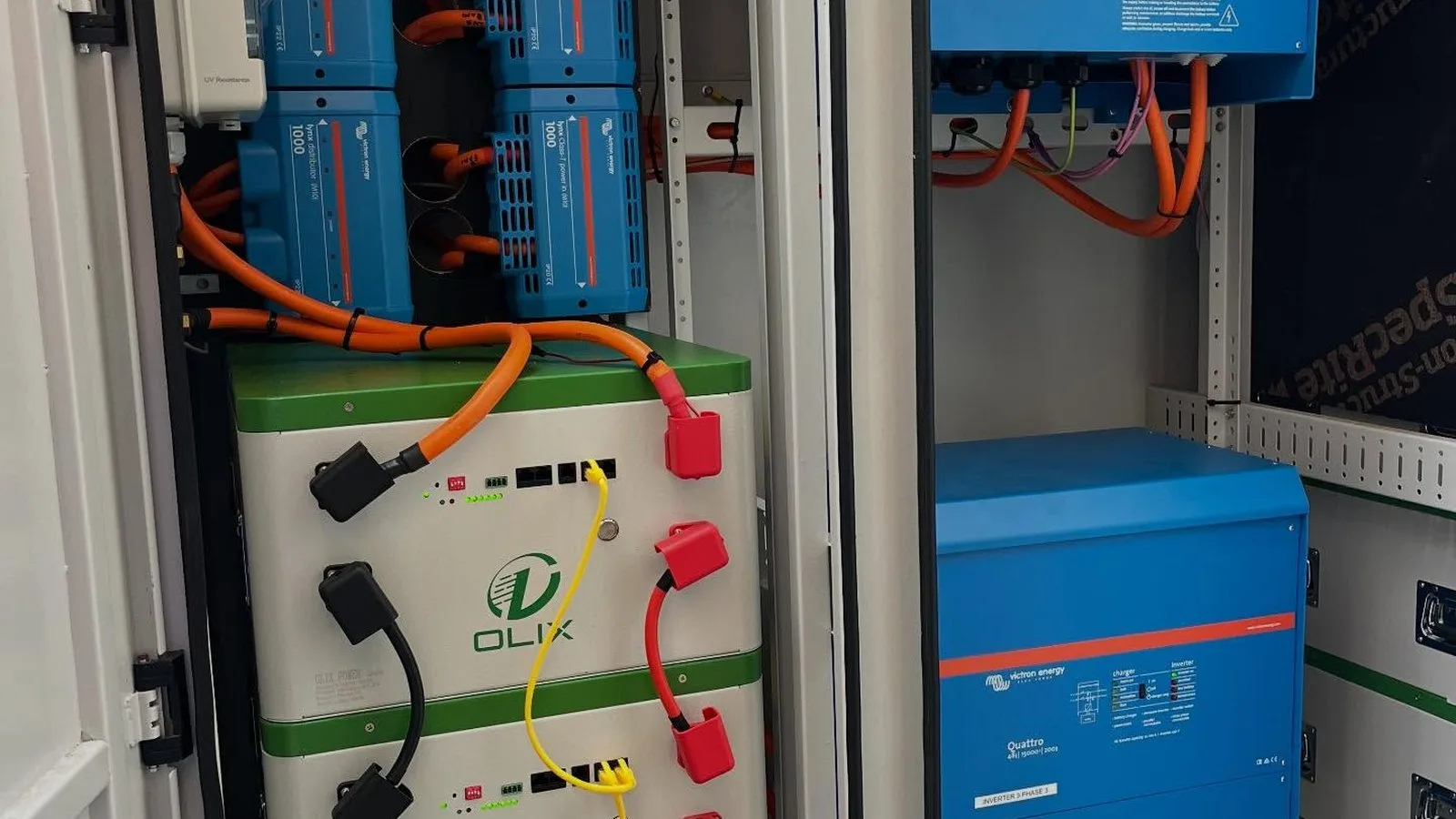 Battery storage bank with inverters wired inside an equipment cabinet